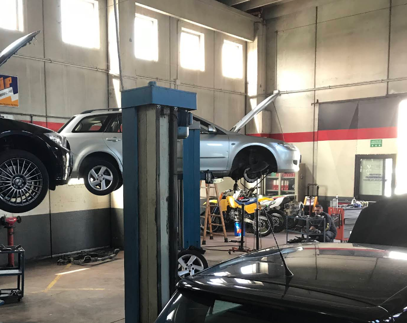 Meccanico al lavoro sul motore di un'auto
